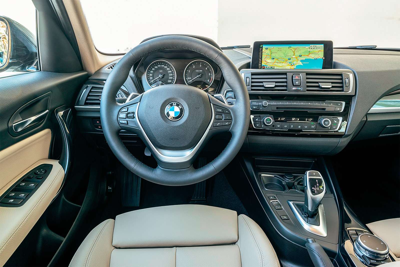 BMW 1-й серии. В список базового оборудования первой серии вошла мультимедийная система iDrive с 6,5‑дюймовым экраном (на фото – опционный, диагональю 8,8 дюйма), кожаный мультируль, двухзонный климат-контроль и порт USB. Архитектура панели осталась прежней.