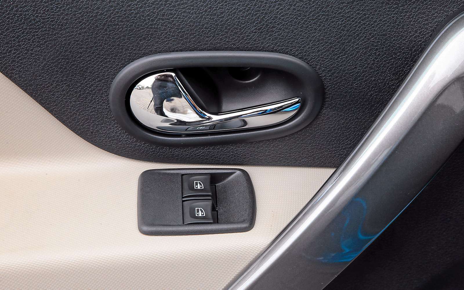 Блок управления стеклоподъемниками на водительской двери Логана купированный: клавиши управления задними стеклоподъемниками вынесены на центральную консоль.