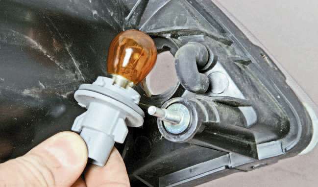 Для замены лампы указателя поворота поворачиваем патрон лампы против часовой стрелки и вынимаем его из корпуса блок-фары.