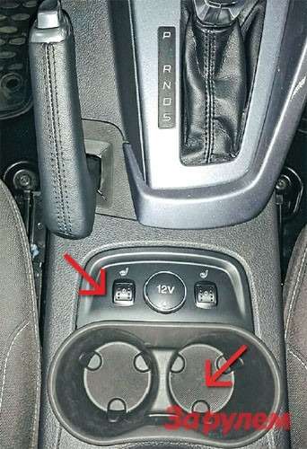 На машинах в дорогих комплектациях для регулировки ручника потребуется снять нишу для подстаканников и панель управления подогревом сидений (красная стрелка).